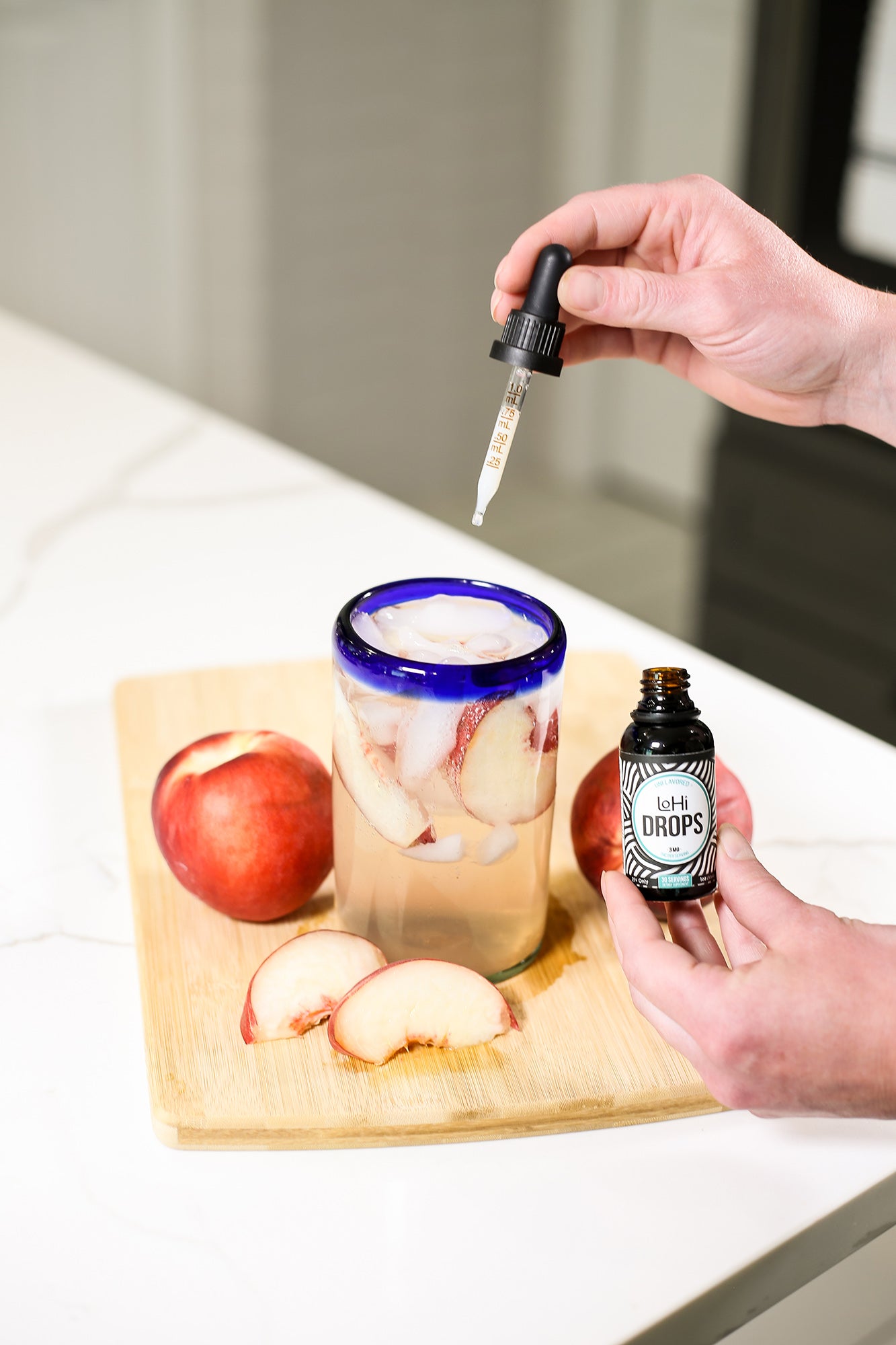 A woman adding LoHi THC drops to a ginger-peach fizz refresher.