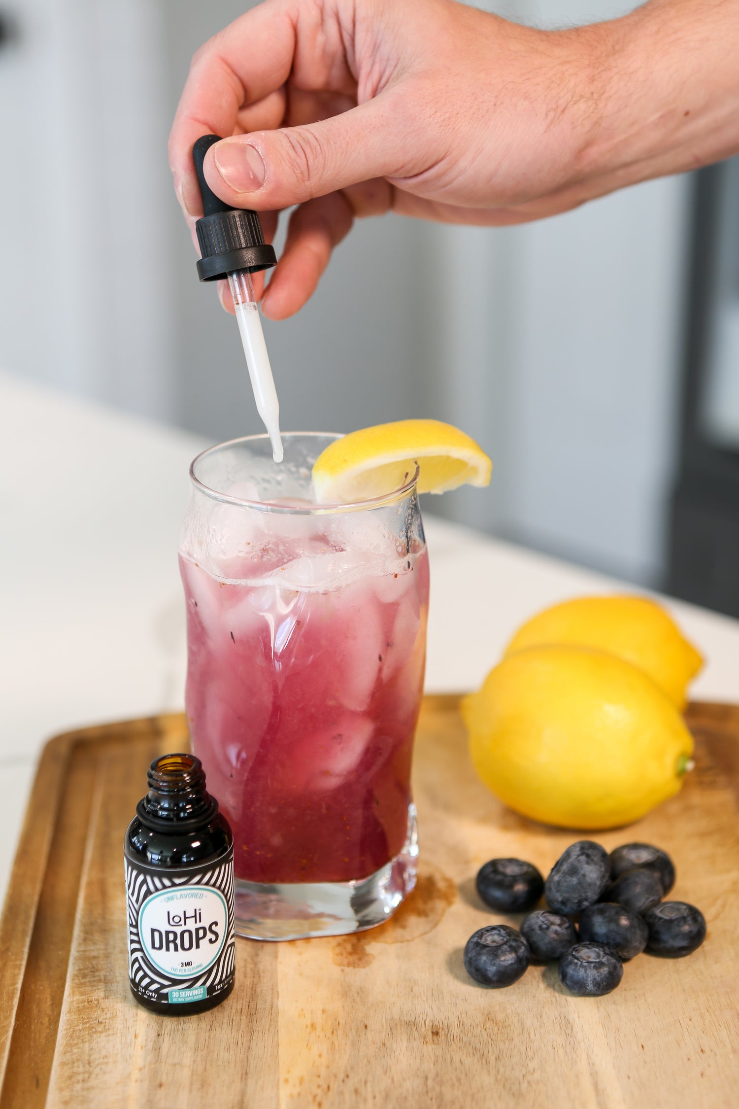 Adding LoHi THC Drops to a refreshing lavender-blueberry lemonade
