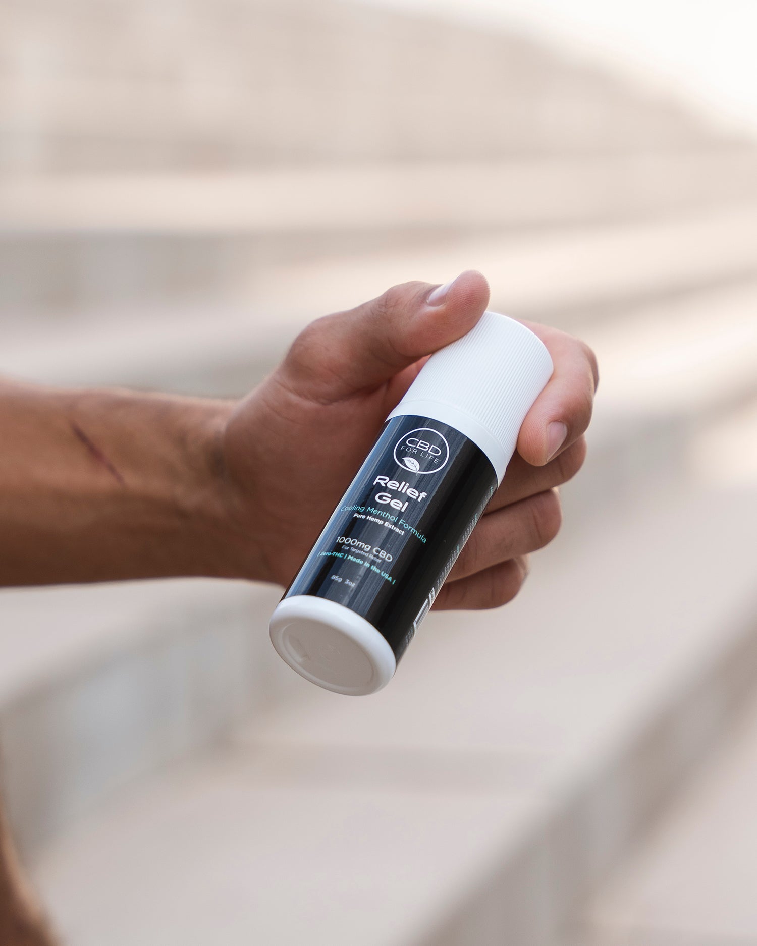 CBD relief gel being held by a mans hand