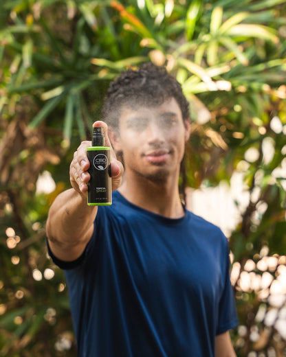 A young man using CBD topical spray